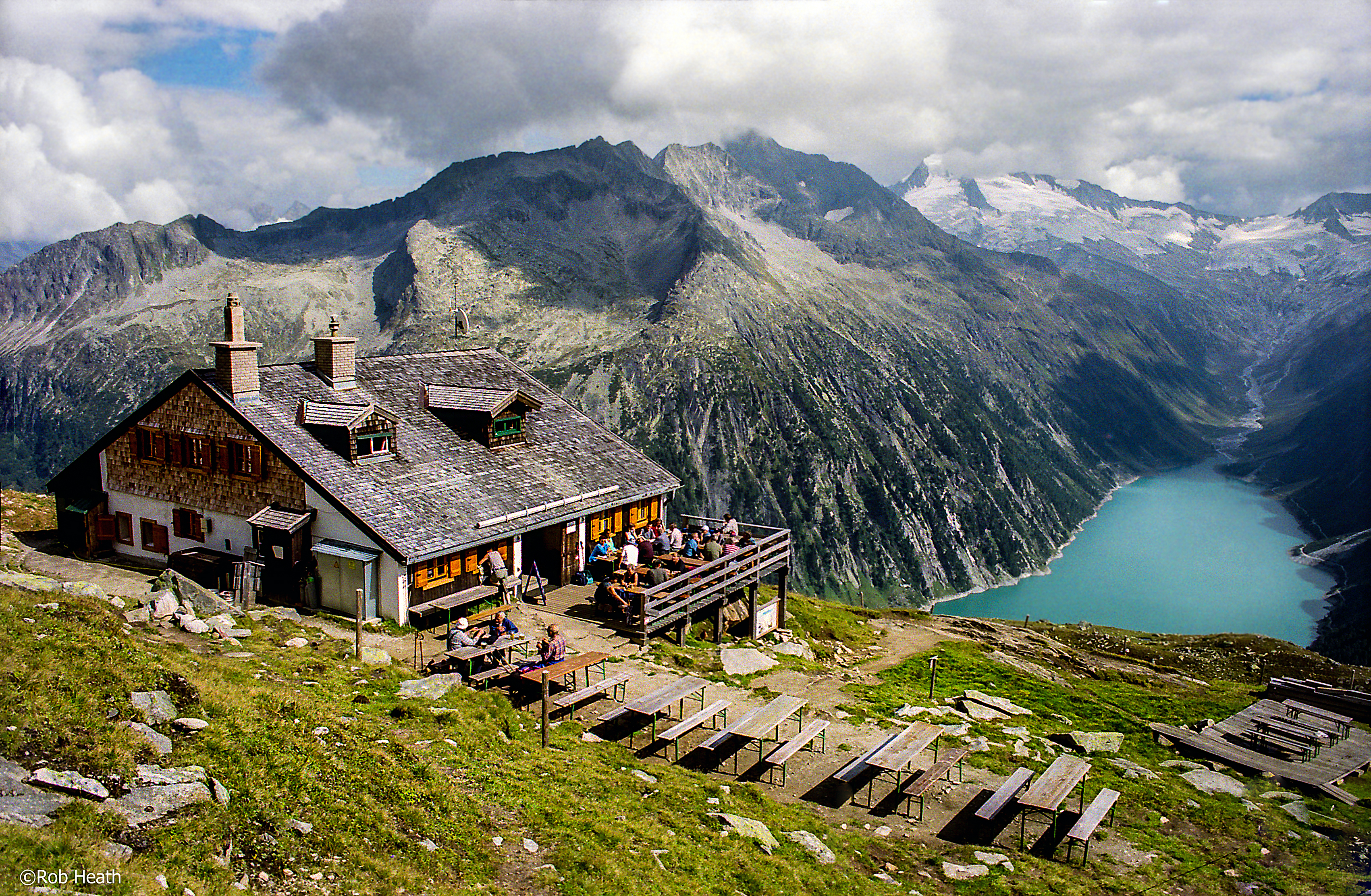 Snow-covered peaks above the Zillertal valley in Austria with the village of Mayrhofen visible below, under a clear blue sky