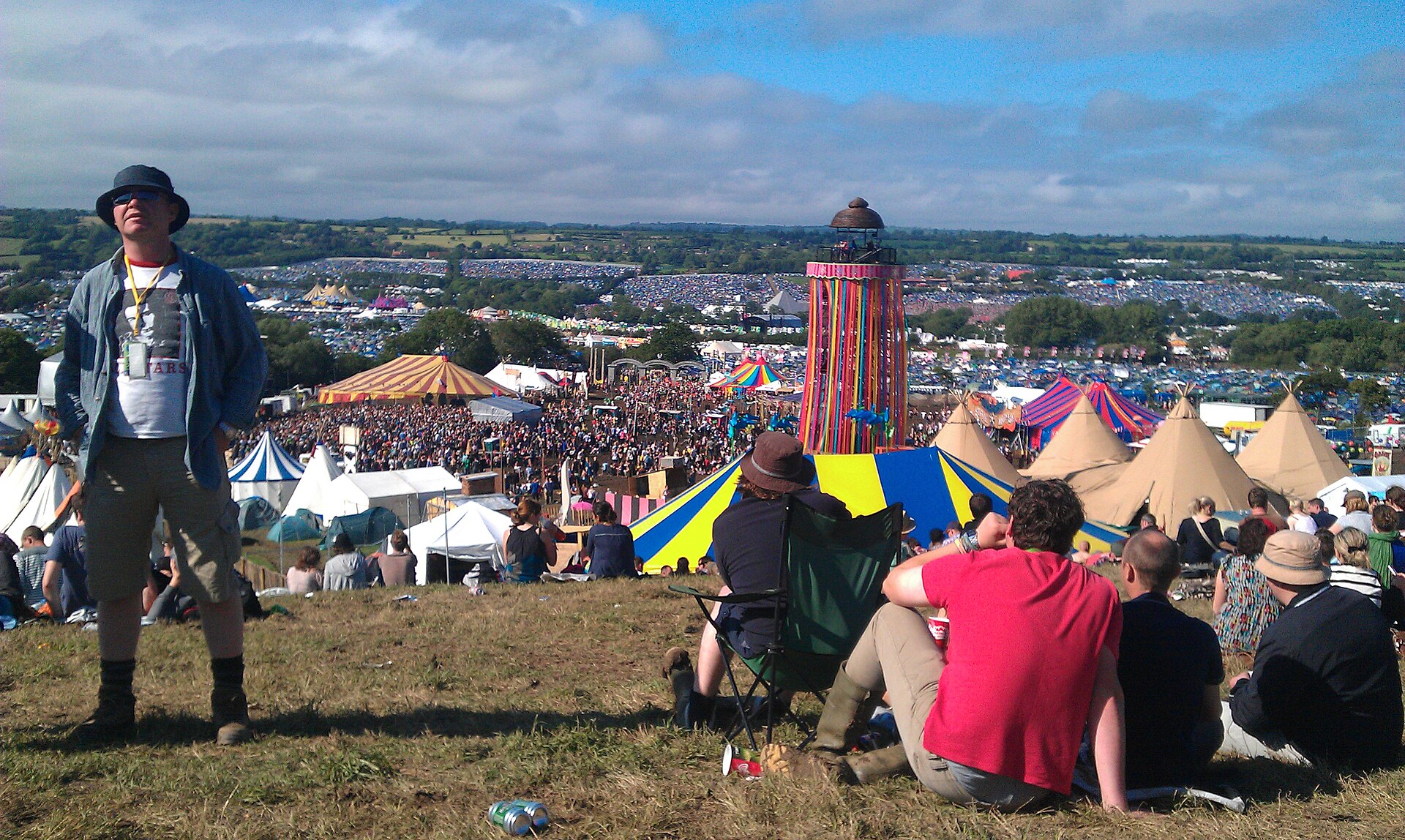The Glastonbury Festival Pyramid Stage at sunset with a massive crowd stretching back across Worthy Farm